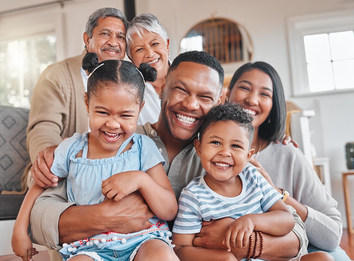 Portrait, smile and big family in home with kids, grandma and grandfather bonding in living room. Face, mother and father hug children, happy grandparents and generations laughing together for love